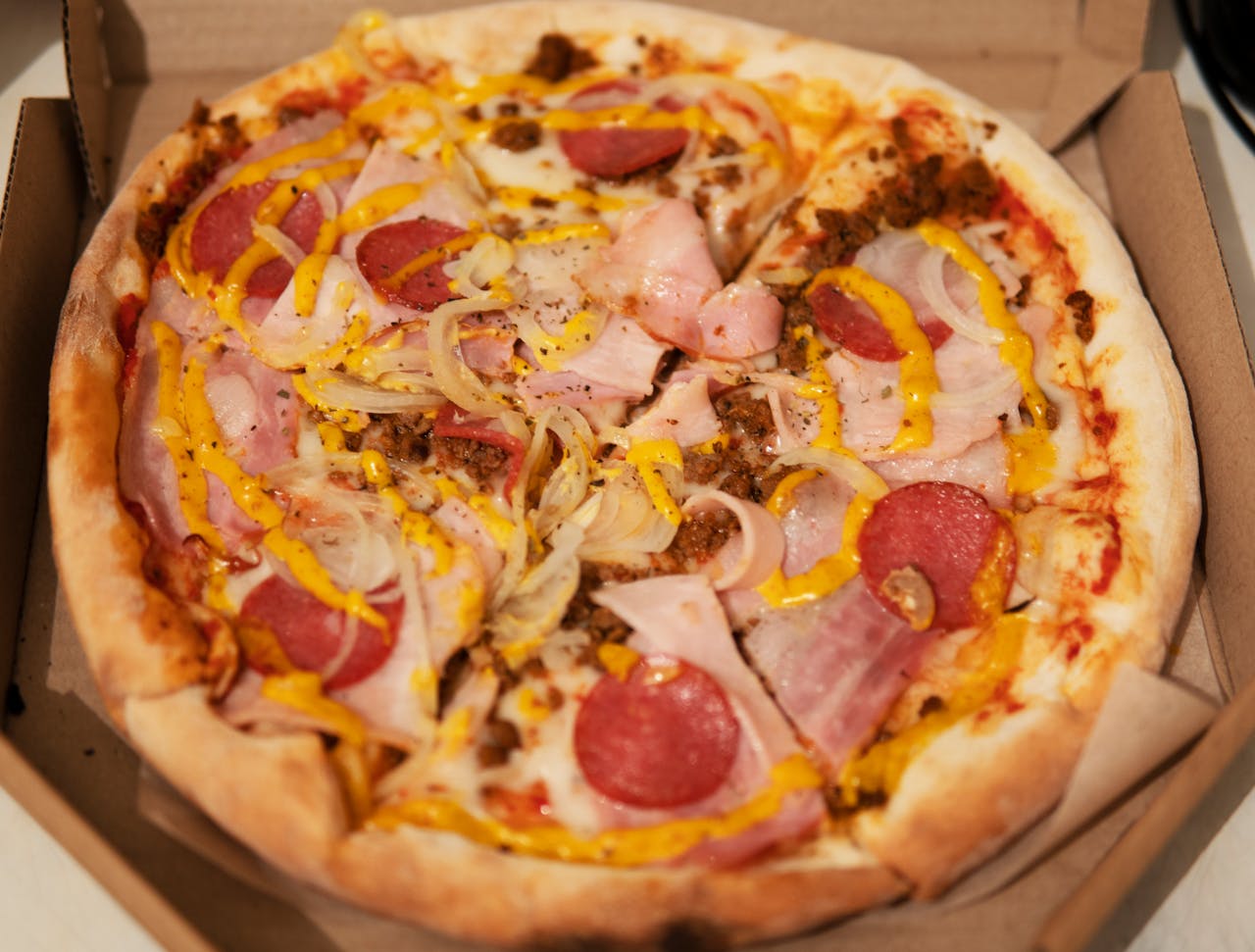 Mouthwatering pizza with pepperoni, melted cheese, and vibrant toppings in an open box.